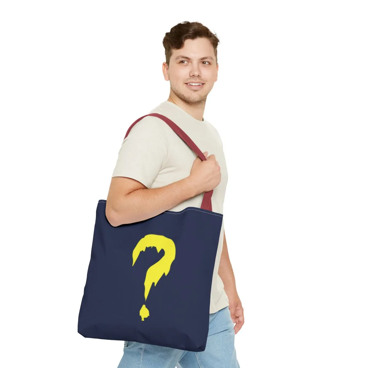 A blue canvas tote with a red handle and a large yellow question mark.