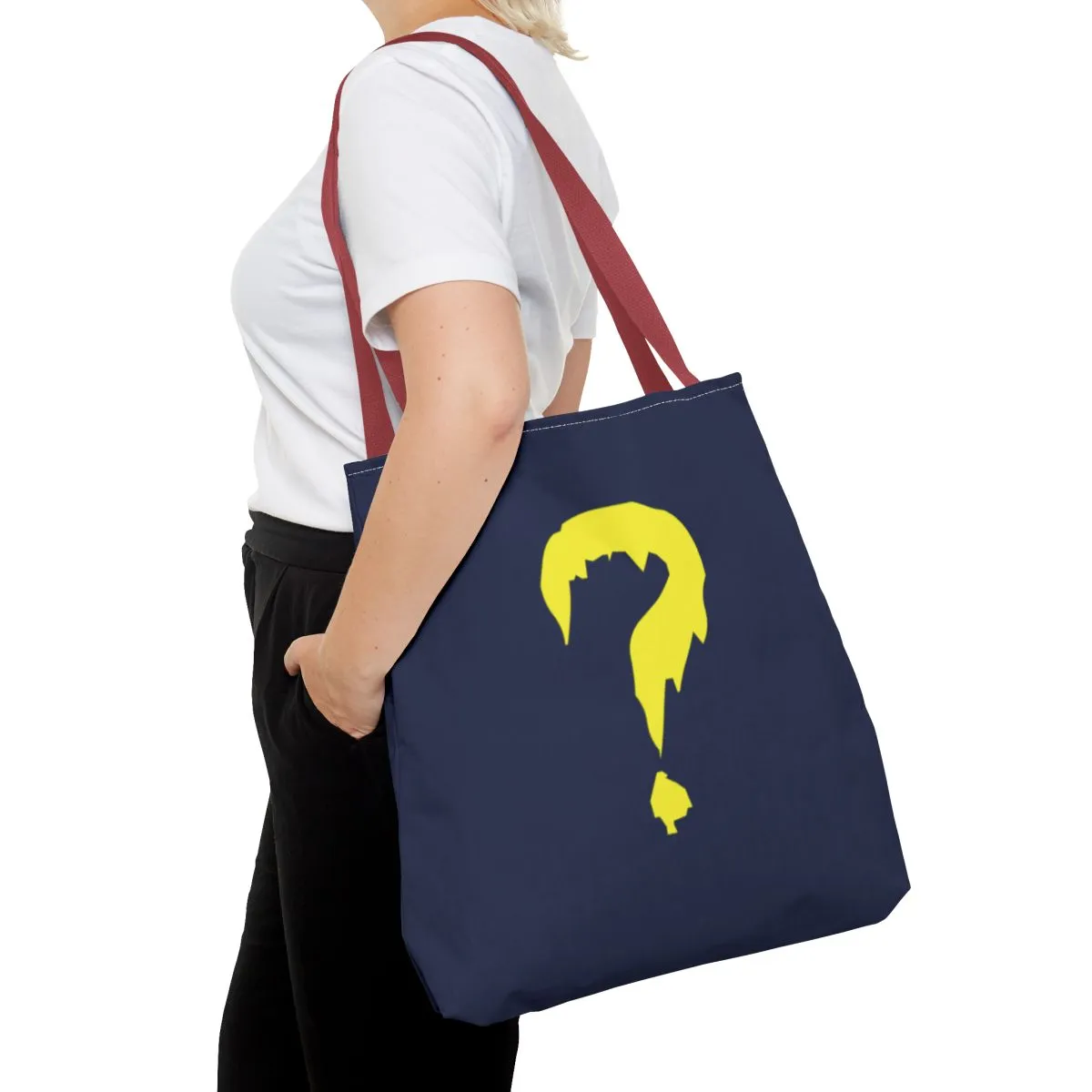 A blue canvas tote with a red handle and a large yellow question mark.